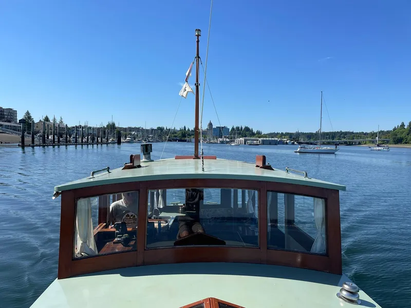 Slide: The Image of 1931 Jensen Cruiser navigating a calm harbor under a clear blue sky. - 26