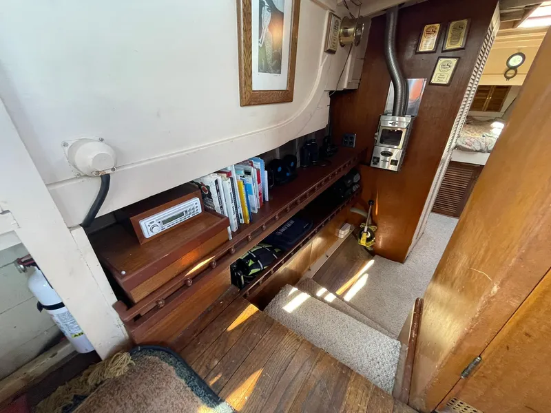 Slide: The Image of Interior of a 1931 Jensen Cruiser with wooden shelves, books, and vintage decor. - 28