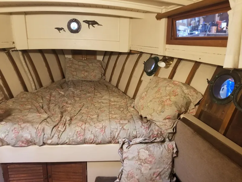 Slide: The Image of Cozy cabin interior of a 1931 Jensen Cruiser with floral bedding and porthole windows. - 3