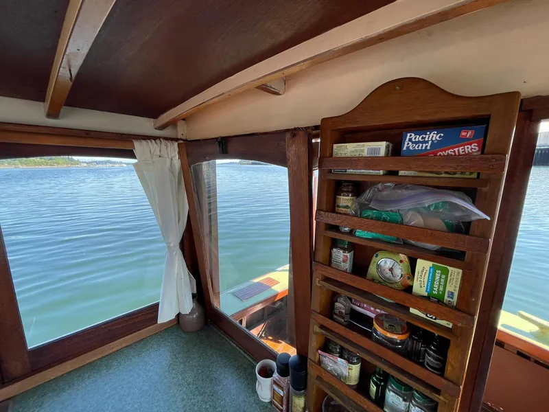 Slide: The Image of Interior view of a 1931 Jensen Cruiser with wooden shelves and a scenic water view. - 31