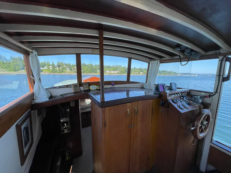 Slide: The Image of Interior of a 1931 Jensen Cruiser boat with wooden helm and panoramic windows. - 6