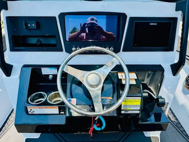 Slide: The Image of 2023 Scarab 255 Open ID boat dashboard with steering wheel and electronic displays. - 13