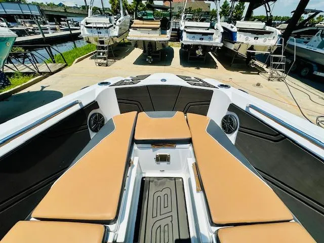 Slide: The Image of 2023 Scarab 255 Open ID boat interior with tan seating at a marina. - 16