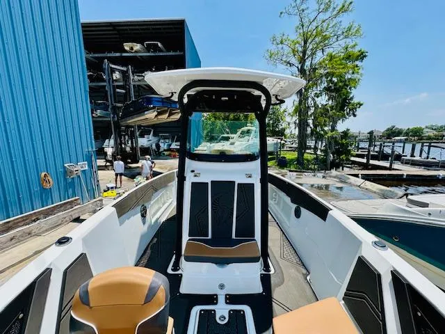 Slide: The Image of 2023 Scarab 255 Open ID boat docked at marina with blue building. - 18