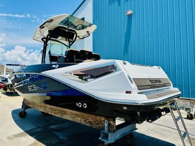 Slide: The Image of 2023 Scarab 255 Open ID boat in a marina, blue and white exterior. - 3