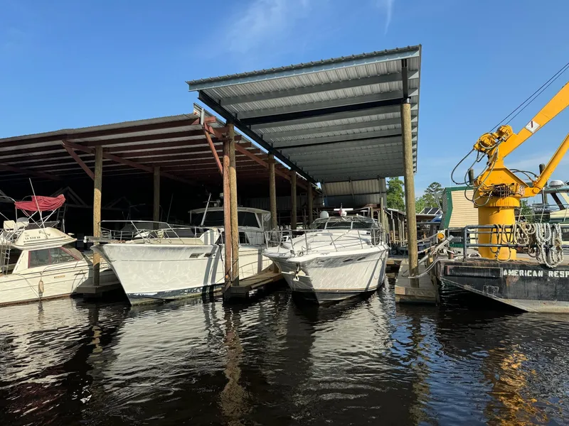 Slide: The Image of Boats docked under a covered marina, featuring a 1995 Sea Ray 500. - 0