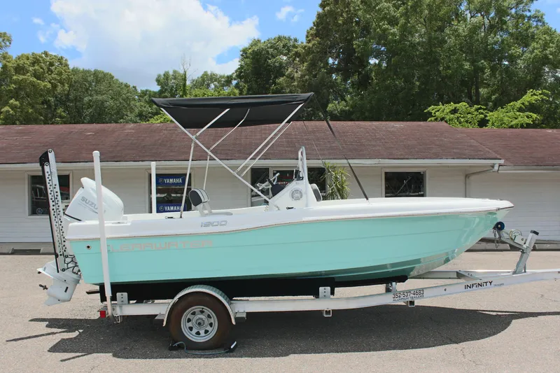 Slide: The Image of 2024 Clearwater 1900 boat on trailer with canopy, parked outdoors. - 4