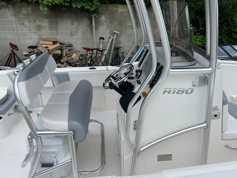 Slide: The Image of 2021 Robalo R180 Center Console boat interior with steering wheel and seating. - 11