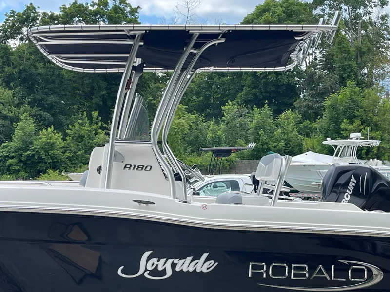 Slide: The Image of 2021 Robalo R180 Center Console boat with canopy, parked outdoors. - 2