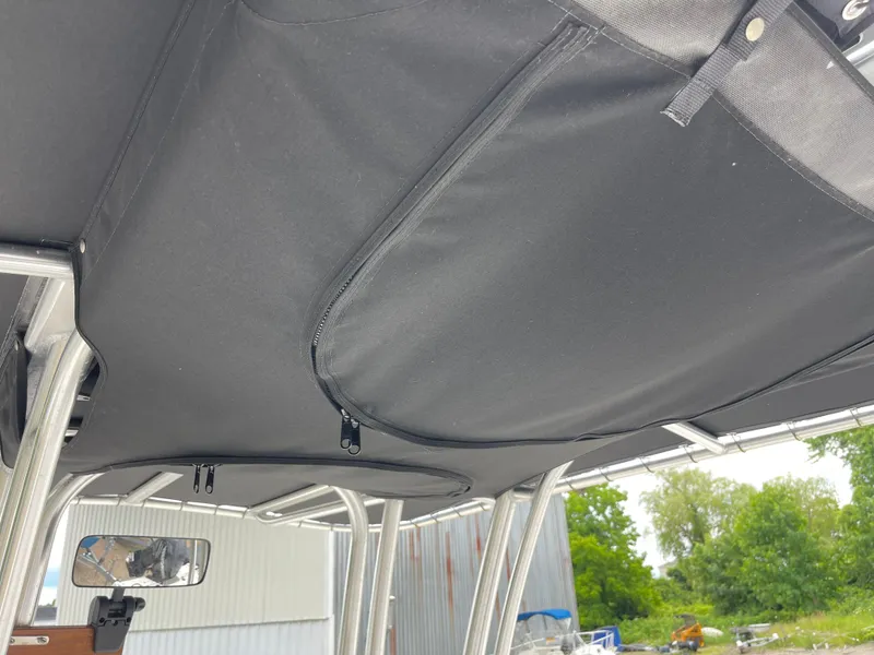 Slide: The Image of 2021 Robalo R180 Center Console boat with black canopy and sturdy frame. - 24