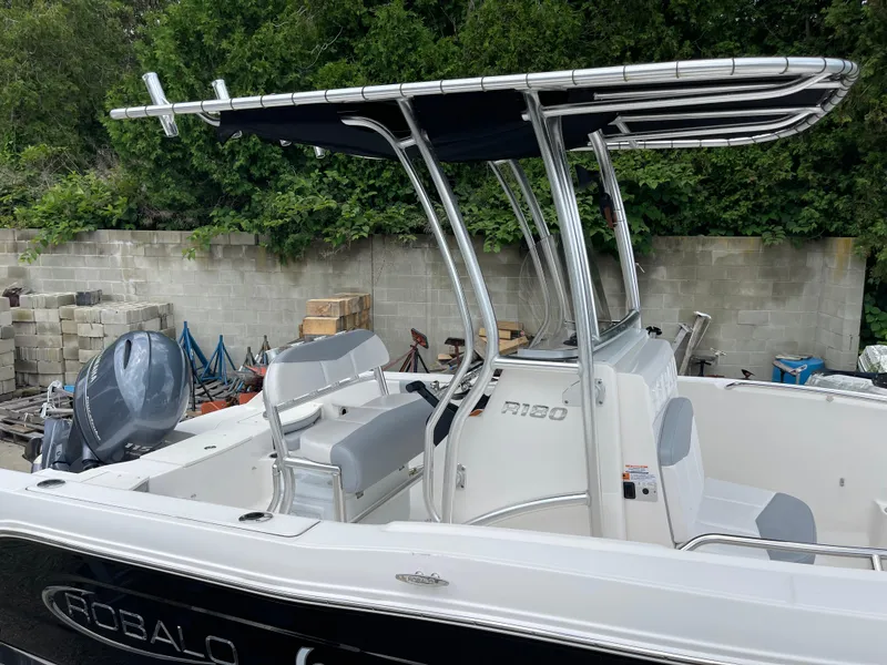 Slide: The Image of 2021 Robalo R180 Center Console boat with T-top, parked outdoors. - 26