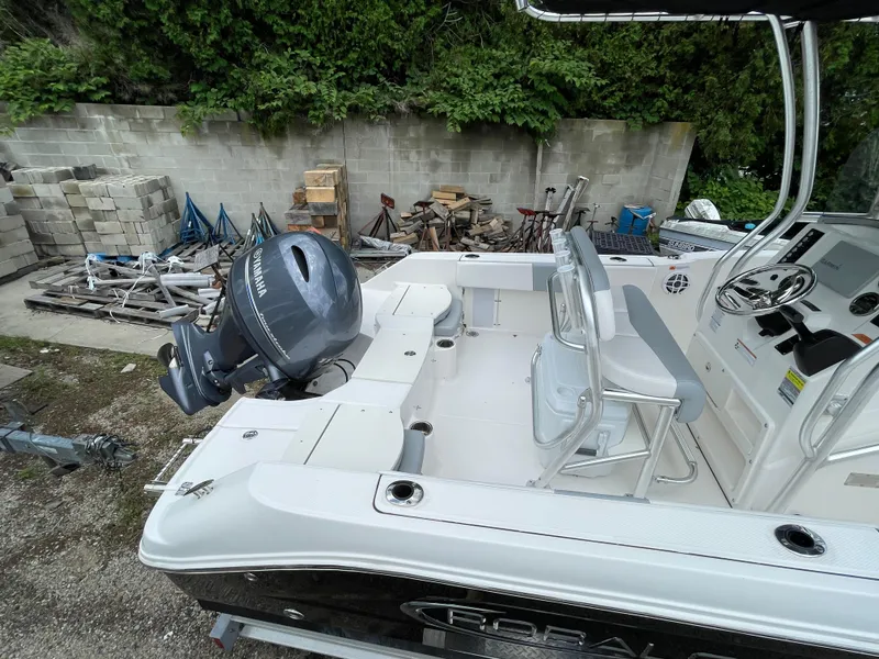 Slide: The Image of 2021 Robalo R180 Center Console boat with outboard motor, parked outdoors. - 27