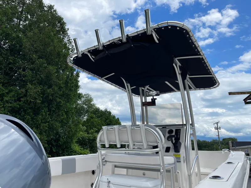Slide: The Image of 2021 Robalo R180 Center Console boat with T-top against a blue sky. - 5
