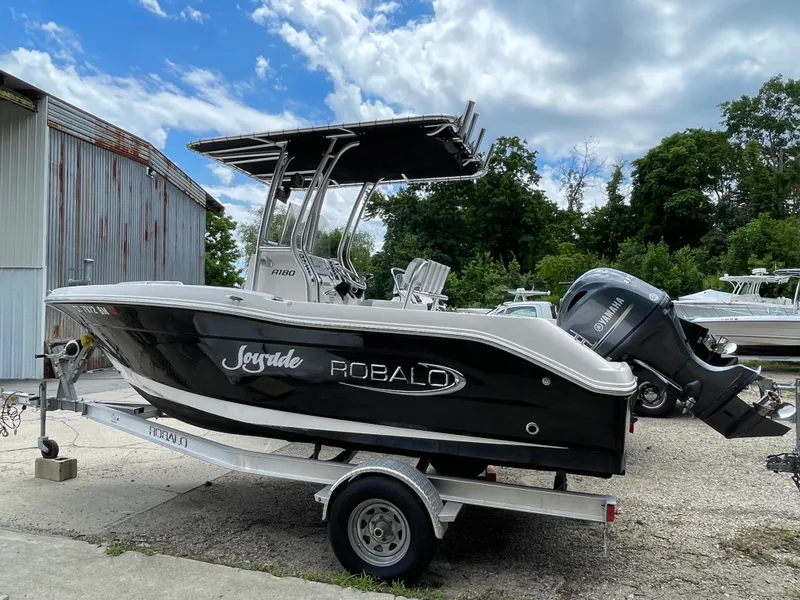 Slide: The Image of 2021 Robalo R180 Center Console boat on trailer, parked outdoors. - 6