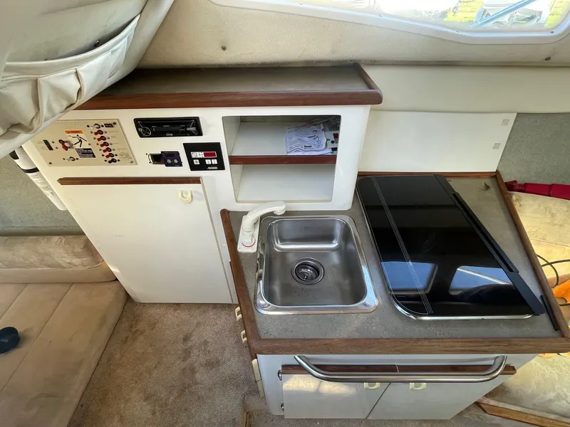 Slide: The Image of 1994 Bayliner 2655 Ciera boat interior kitchen with sink, stove, and storage. - 11