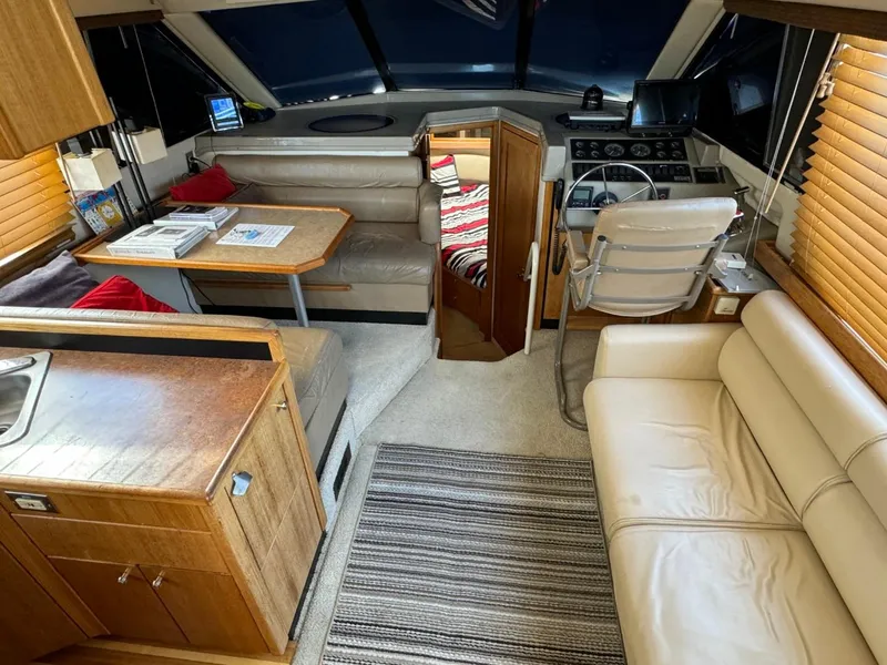 Slide: The Image of 1999 Bayliner 4087 Aft Cabin Motor Yacht interior with seating, helm, and wooden cabinetry. - 10