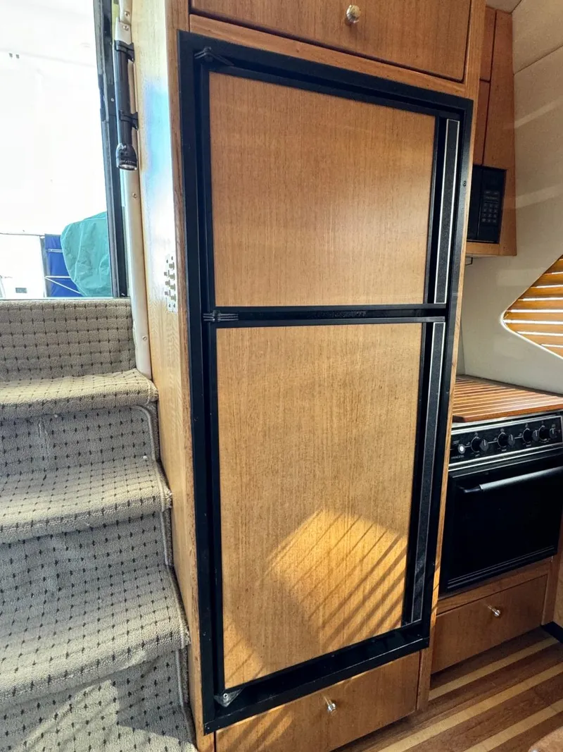 Slide: The Image of 1999 Bayliner 4087 Aft Cabin Motor Yacht interior with wooden cabinetry and staircase. - 15