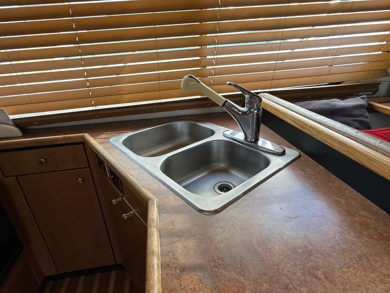 Slide: The Image of 1999 Bayliner 4087 yacht kitchen with double sink and wooden blinds. - 16