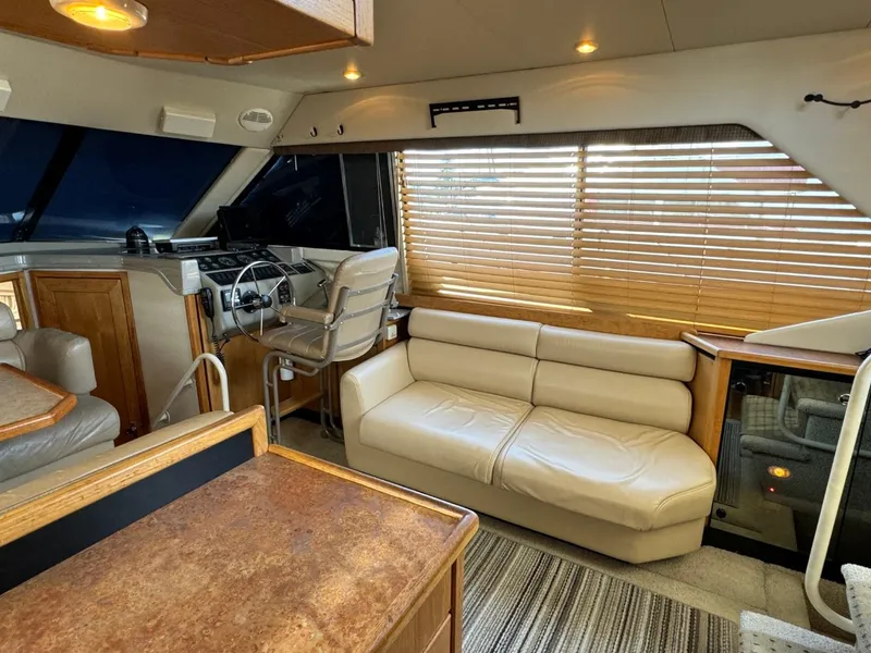 Slide: The Image of 1999 Bayliner 4087 Aft Cabin Motor Yacht interior with helm, sofa, and wooden blinds. - 17