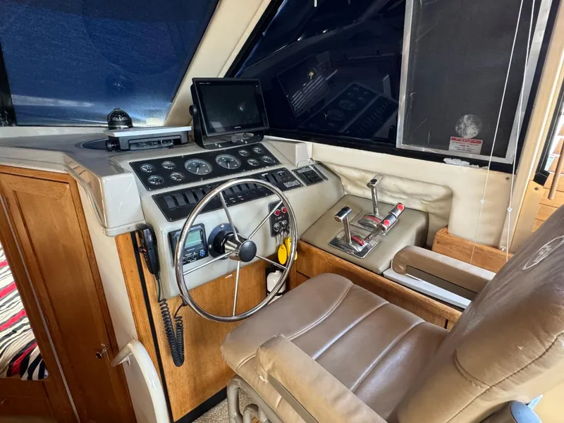 Slide: The Image of 1999 Bayliner 4087 Aft Cabin Motor Yacht helm with steering wheel and control panel. - 18