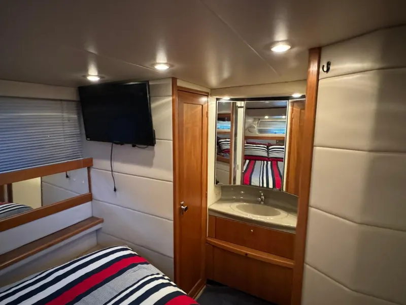 Slide: The Image of 1999 Bayliner 4087 Aft Cabin Motor Yacht interior with bed, TV, and vanity. - 24