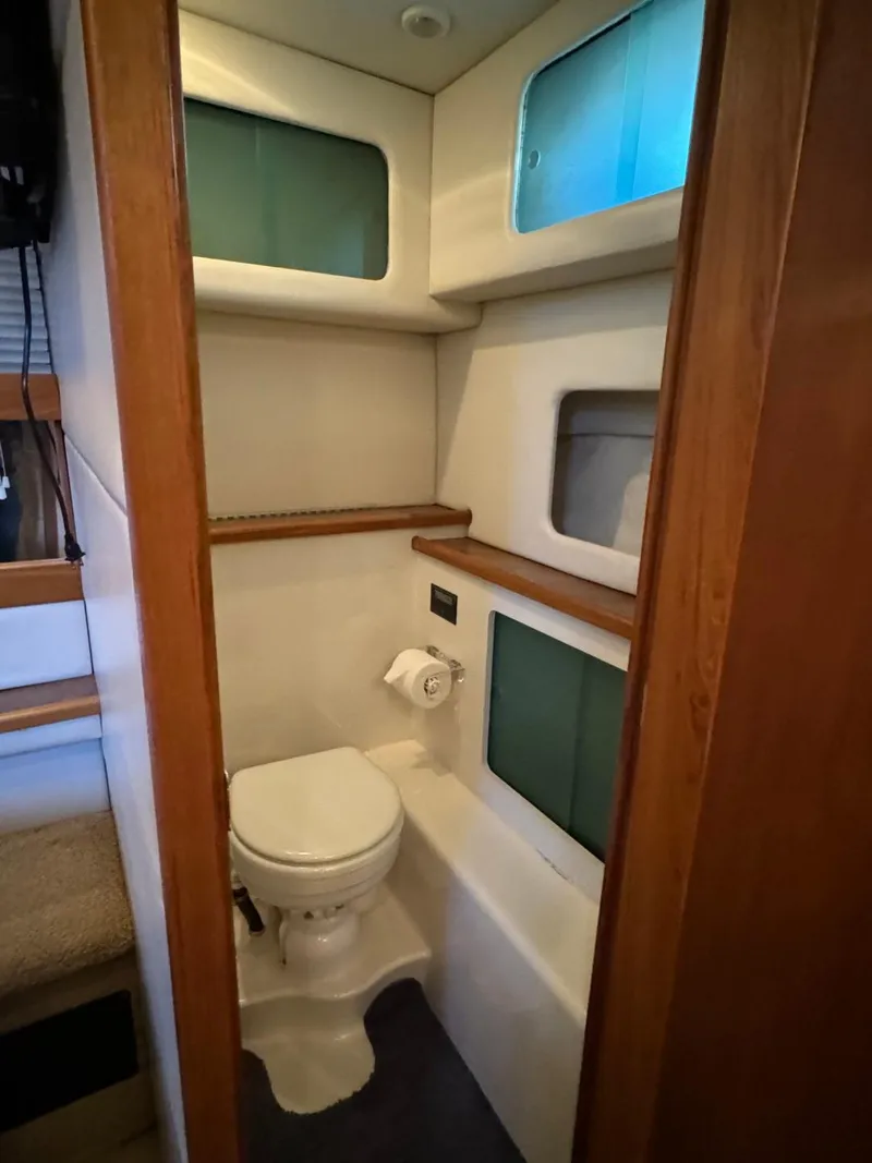 Slide: The Image of 1999 Bayliner 4087 Aft Cabin Motor Yacht bathroom with toilet and storage shelves. - 27
