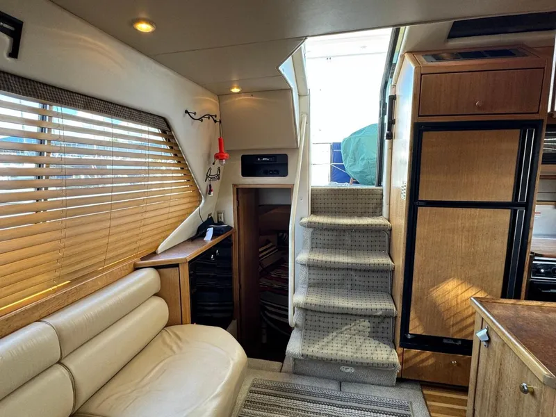 Slide: The Image of Interior of 1999 Bayliner 4087 Aft Cabin Motor Yacht with stairs, seating, and wooden cabinetry. - 35