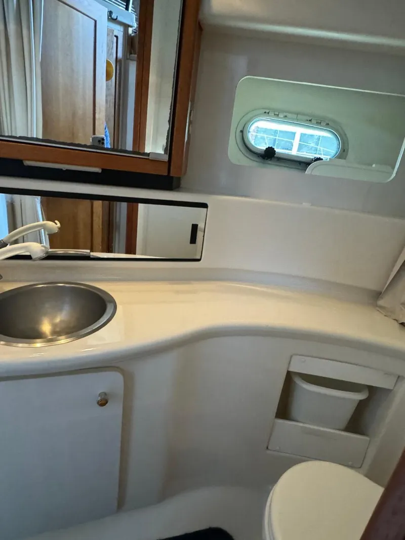 Slide: The Image of 1999 Bayliner 4087 Aft Cabin Motor Yacht bathroom with sink, mirror, and porthole window. - 36