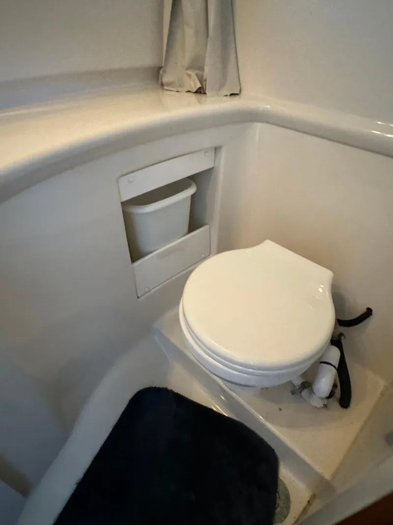 Slide: The Image of 1999 Bayliner 4087 Aft Cabin Motor Yacht bathroom with compact toilet and storage. - 37