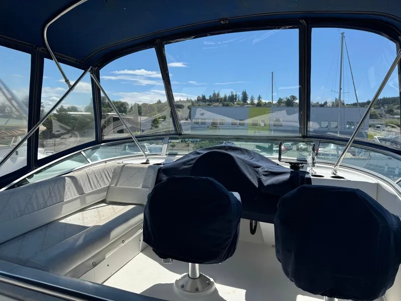 Slide: The Image of 1999 Bayliner 4087 Aft Cabin Motor Yacht cockpit with covered seats and panoramic windows. - 5
