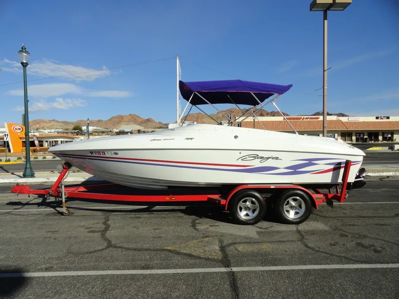 Slide: The Image of 1998 Baja Boss Hammer boat on a red trailer, parked outdoors. - 1