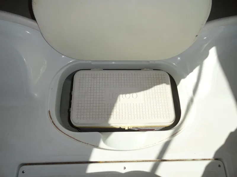 Slide: The Image of Storage compartment of a 1998 Baja Boss Hammer boat with an Igloo cooler. - 13