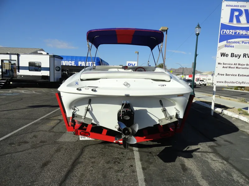 Slide: The Image of 1998 Baja Boss Hammer boat with red and blue canopy in RV dealership lot. - 23