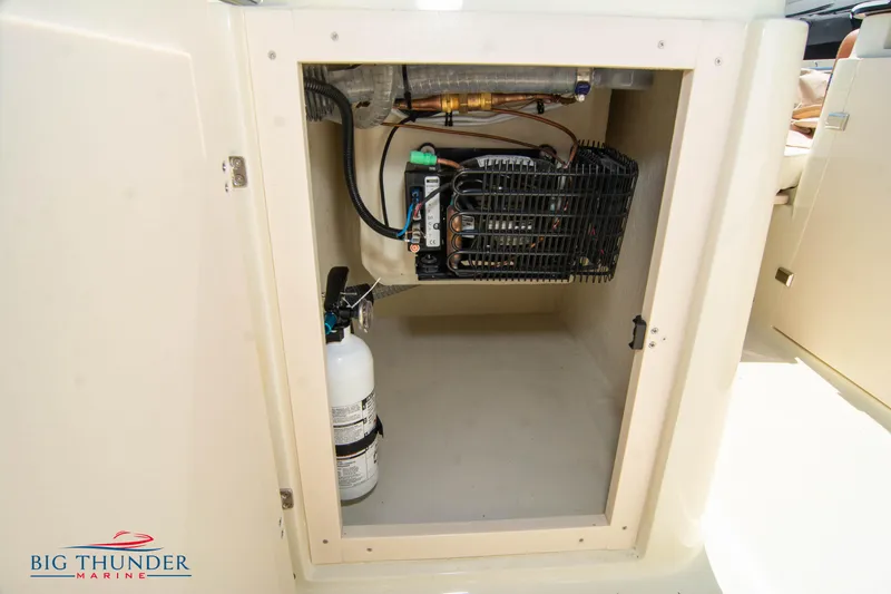 Slide: The Image of Storage compartment of 2024 Capoforte SX200 boat with fire extinguisher and cooling unit. - 28