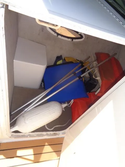 Slide: The Image of Storage compartment of a 1996 Four Winns 240 Horizon boat with boating equipment. - 11