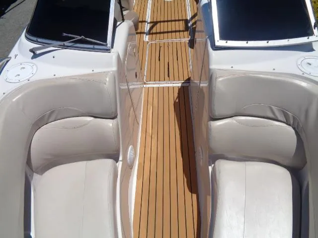 Slide: The Image of 1996 Four Winns 240 Horizon boat interior with teak flooring and white leather seats. - 16