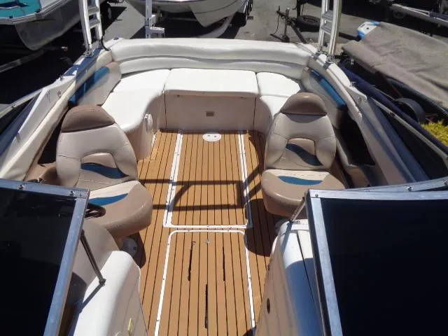Slide: The Image of 1996 Four Winns 240 Horizon boat interior with seating and wooden deck. - 18