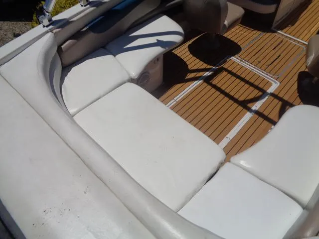 Slide: The Image of 1996 Four Winns 240 Horizon boat interior with white seating and wooden floor. - 23