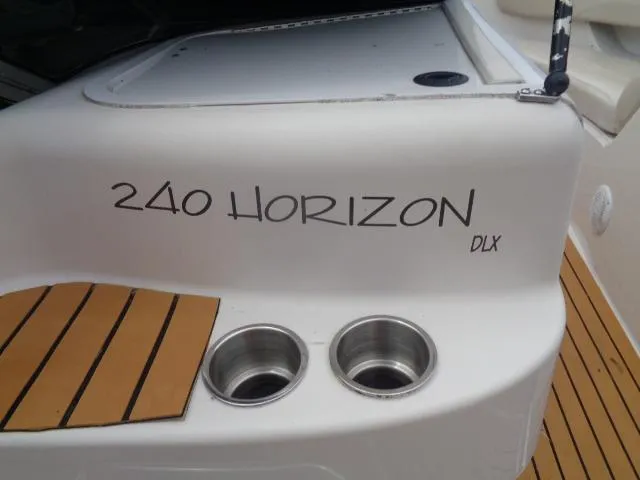 Slide: The Image of 1996 Four Winns 240 Horizon boat with dual cup holders and teak flooring. - 27