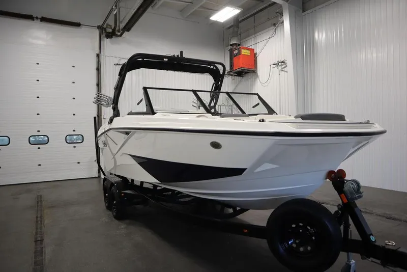 Slide: The Image of 2024 Heyday H22 boat in a showroom, white exterior, black accents, on a trailer. - 3