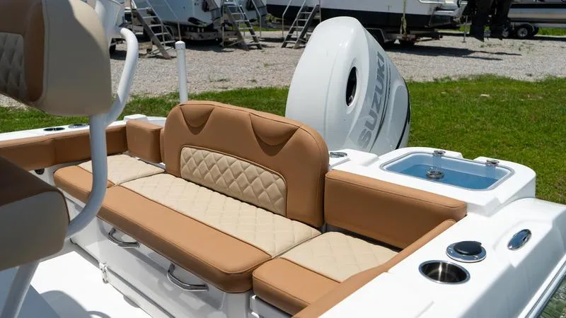Slide: The Image of 2024 NauticStar 222 OSL boat with tan seating and Suzuki outboard motor. - 12