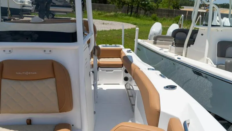 Slide: The Image of 2024 NauticStar 222 OSL boat interior with tan seating and white deck. - 3