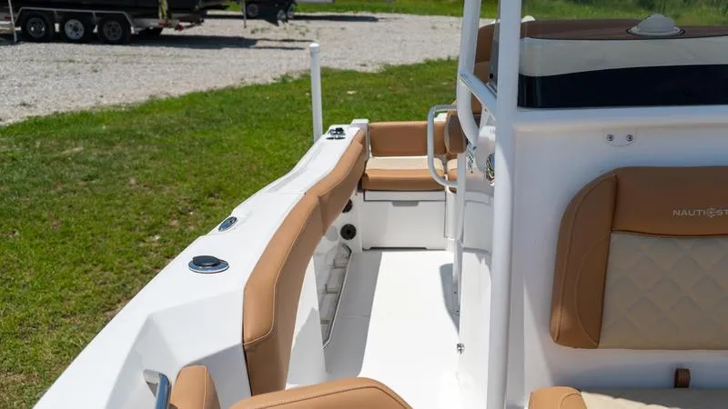 Slide: The Image of 2024 NauticStar 222 OSL boat interior with tan seating and white deck. - 7