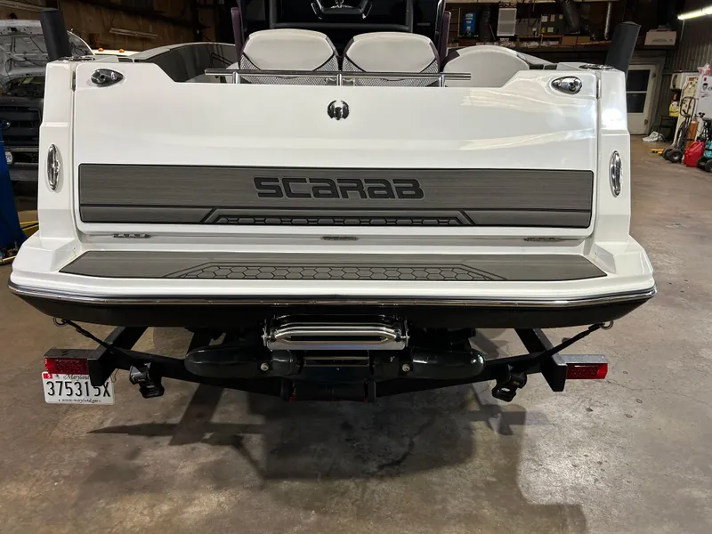 Slide: The Image of 2021 Scarab 255 Open ID boat rear view in a garage. - 3