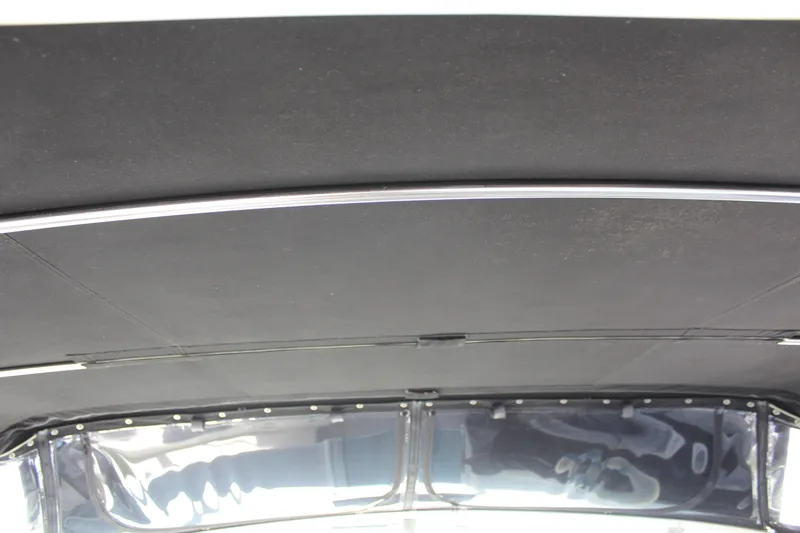 Slide: The Image of Interior roof of a 1996 Trojan 440 Express boat, featuring sleek black paneling. - 15