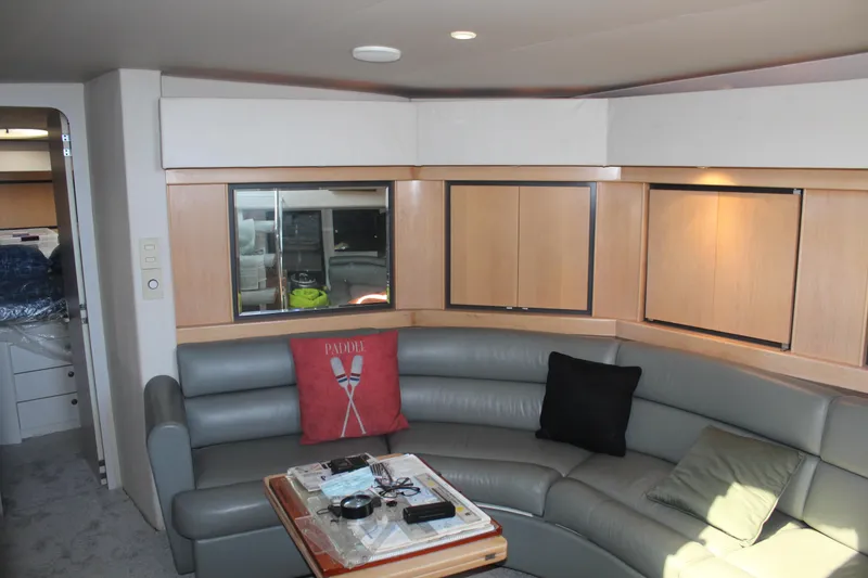 Slide: The Image of Interior of 1996 Trojan 440 Express yacht with curved seating and wooden cabinetry. - 28