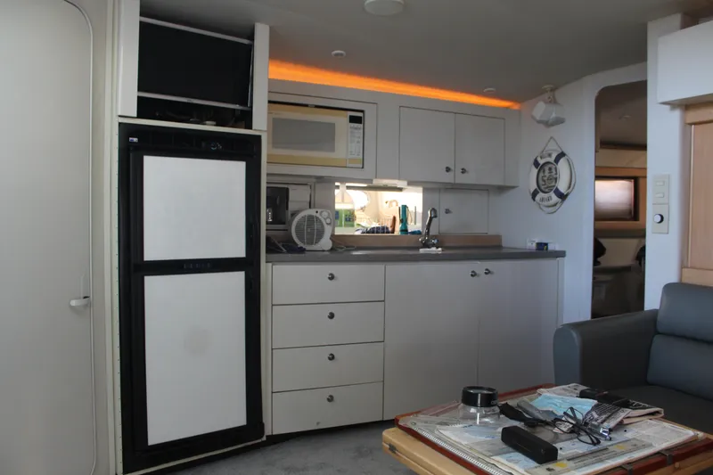 Slide: The Image of Interior of a 1996 Trojan 440 Express yacht with kitchenette and modern amenities. - 29