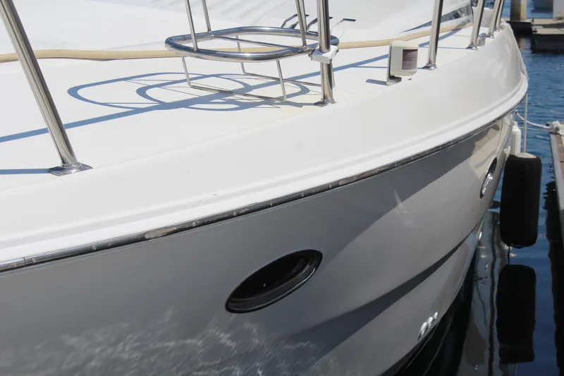 Slide: The Image of 1996 Trojan 440 Express yacht docked, showcasing sleek white hull and stainless steel railings. - 3