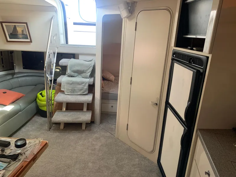 Slide: The Image of Interior of 1996 Trojan 440 Express yacht with cozy seating and compact kitchen area. - 31