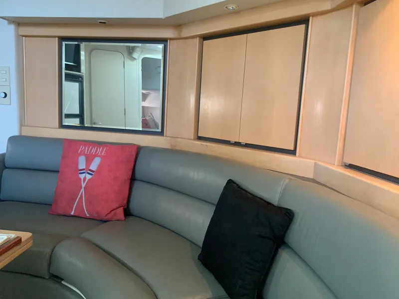 Slide: The Image of Interior of a 1996 Trojan 440 Express yacht with curved seating and decorative pillows. - 32